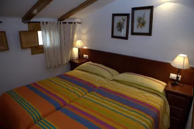 a bedroom with a colorful bed with two lamps at Casa rural Vista Alegre , cerca de Valencia y Castellón in Caudiel