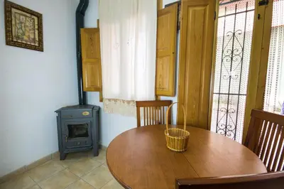 a dining room with a wooden table and a stove at Casa rural Vista Alegre , cerca de Valencia y Castellón in Caudiel
