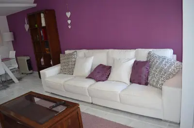 a white couch in a living room with purple walls at Sweet Caroline Apartment in Valencia
