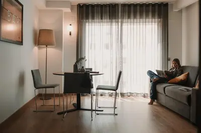 a woman sitting on a couch looking out a window at Parker The Urban Flats in Valencia
