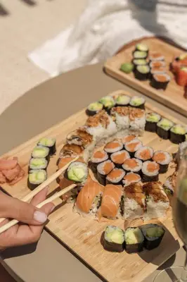 a plate of sushi with chopsticks on a table at Meraki Beach Hotel - Only Adults in Playa Pobla de Farnals