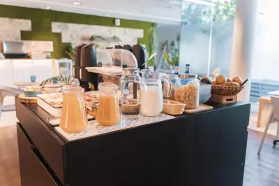 a buffet line with jars of orange juice and bread at Meraki Beach Hotel - Only Adults in Playa Pobla de Farnals