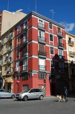 a red building with a cat walking in front of it at Apartment Boutique in Valencia
