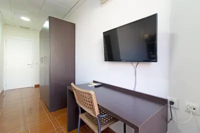 a room with a desk with a tv on a wall at Hotel Sagunto in Sagunto