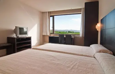 a bedroom with a large bed with a large window at Hotel Puerta de la Serrania in Lliria