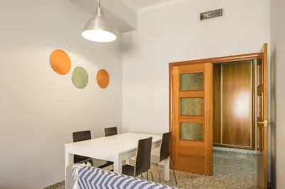 a dining room with a white table and a wooden door at Macflats Valencia Puerto in Valencia