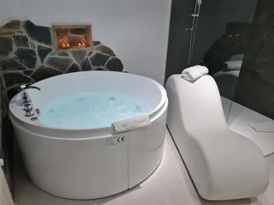 a bathroom with a hot tub and a toilet at Alojamientos Segóbriga Rural (Artesa) in Segorbe