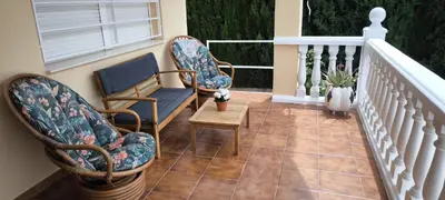a balcony with two chairs and a table on a staircase at Adosado Calle Mar Cantabrico in Puebla de Vallbona