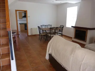 a bedroom with a table and chairs and a fireplace at Adosado Calle Mar Cantabrico in Puebla de Vallbona