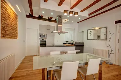 a kitchen with a glass table and white chairs at Beds & Breaks Boyvin in Valencia