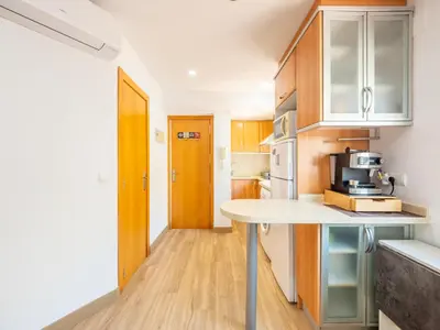 a kitchen with wooden cabinets and a white counter top at Ático de Lujo Plaza Ayuntamiento in Valencia