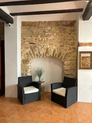 a patio with two chairs and a stone wall at Apartamentos turísticos 