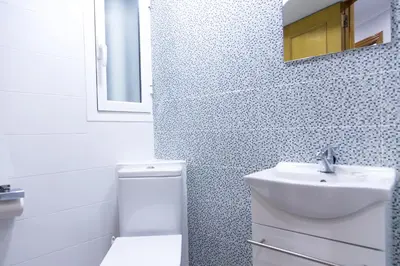a bathroom with a sink and a toilet and a mirror at MD Vila Barbera in Valencia