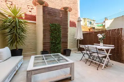 a patio with a couch and a table on a balcony at MD Pelayo in Valencia
