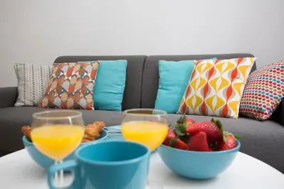 a table with two glasses of orange juice and a bowl of fruit at Eco-Friendly Apartments in Valencia