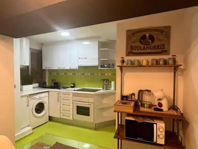 a kitchen with white cabinets and a green floor at Apartamentos El Olivo in Valencia