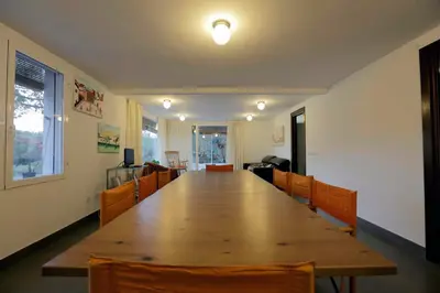 a large wooden table in a room with chairs at El Campillo, casa de campo cerca de la playa in Navajas