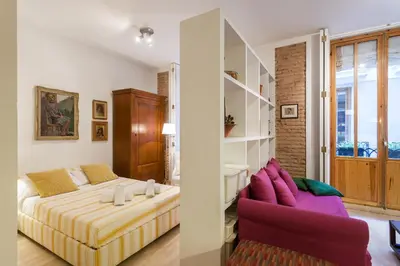 a bedroom with a bed and a purple couch at My Loft 4 You Borgia in Valencia