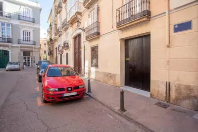 a red car parked on the side of a street at Apartamento Horno in Valencia