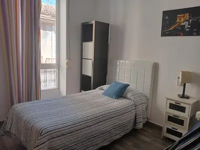 a bedroom with a bed with a blue pillow on it at Lola Apartment Encorts in Valencia