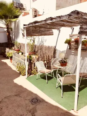 a patio with a table and chairs under a pergola at La casita Santa Bárbara in Macastre