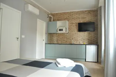 a room with a kitchen with a bed and a microwave at La Casa Verde - Ruzafa in Valencia