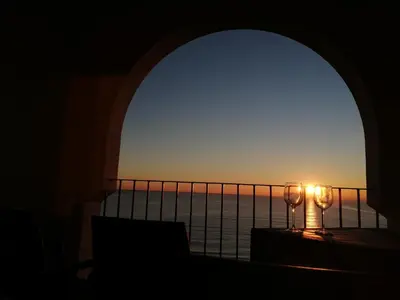 a view of the ocean from a balcony with two wine glasses at La Vista al mar de Belén in Port Saplaya