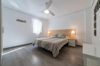 a bedroom with a bed and a ceiling fan at Piso Carolina in Valencia