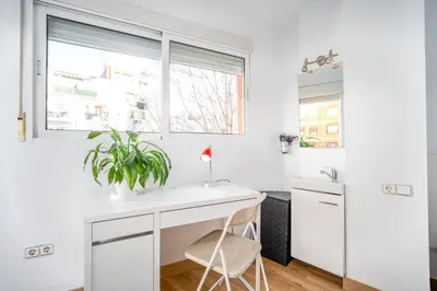a white kitchen with a desk and a plant at Atico Ruzafa Valencia centro in Valencia