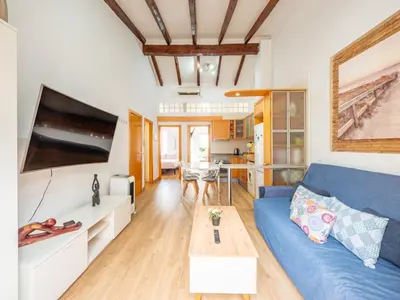 a living room with a blue couch and a table at Atico Ruzafa Valencia centro in Valencia