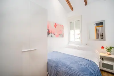 a white bedroom with a bed and a window at Atico Ruzafa Valencia centro in Valencia