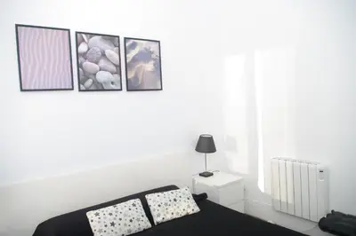 a white bedroom with a bed and three pictures on the wall at Carlos & Ana Amplio Apartamento 4 Habitaciones Centro Valencia in Valencia