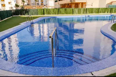 a swimming pool with blue tiles in a building at Apartamento con Vista al Mar in Tavernes de Valldigna
