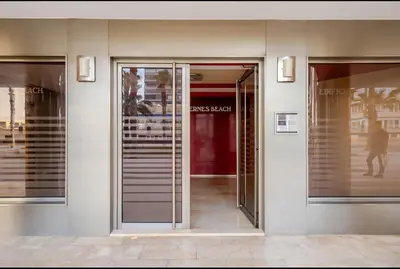 a facade of a building with a red door at Apartamento con Vista al Mar in Tavernes de Valldigna