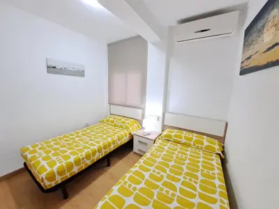 two beds in a room with yellow and white sheets at Céntrico apartamento en Valencia próximo parada de metro Ángel Guimerà in Valencia