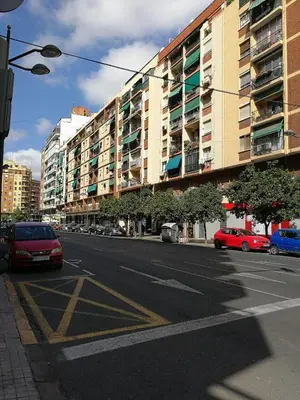 an empty street with cars parked on the side of a building at Céntrico apartamento en Valencia próximo parada de metro Ángel Guimerà in Valencia