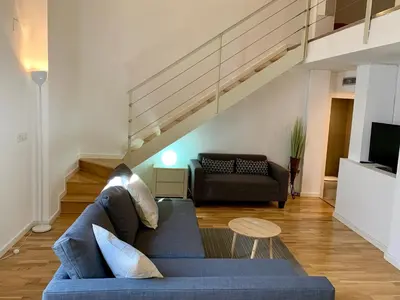 a living room with a blue couch and a staircase at La casita de Palomar - PalomarGroup in Valencia