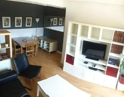a living room with a tv and a couch and a table at Piso Playa Patacona/Malvarrosa in Valencia