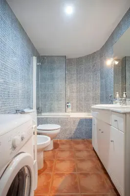 a blue tiled bathroom with a toilet and a sink at Apartamento Alta in Valencia