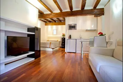 a living room with a couch and a tv and a kitchen at Sun Studio Valencia in Valencia