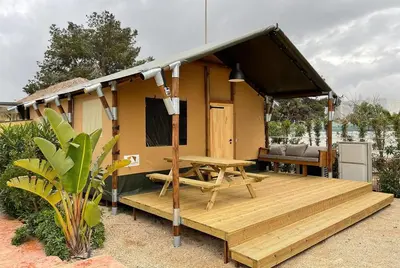 a house with a wooden deck and a picnic table at Devesa Gardens in El Saler