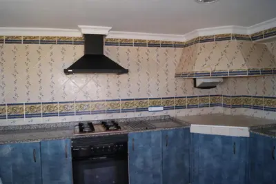 a kitchen with blue cabinets and a black stove at Casa Pescadores de Vallterra in El Palmar