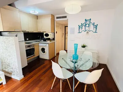 a kitchen with a glass table and white chairs at Petit Palomar - PalomarGroup in Valencia