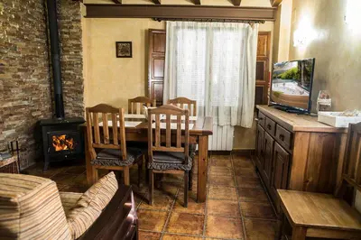 a dining room with a table and a fireplace at Cases Rurals El Castell in Torres-Torres