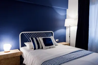 a bedroom with a large bed with blue walls at B&B El Mercat in Valencia