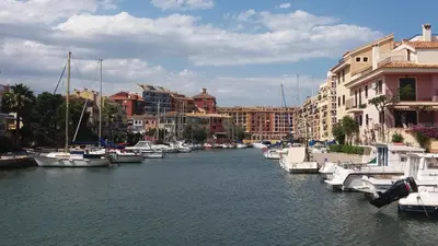 a group of boats docked in a river with buildings at APARTMENTSUITESPAIN Beach Economy in Valencia