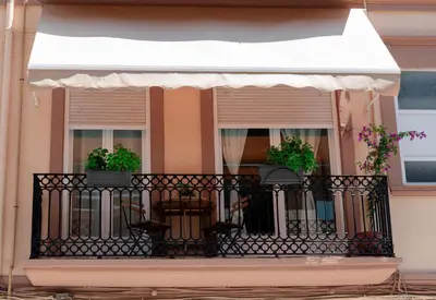 a wooden table and benches on a balcony at Your home in Valencia in Valencia