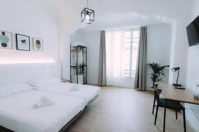a white bedroom with a desk and a bed at Concept Rooms in Valencia