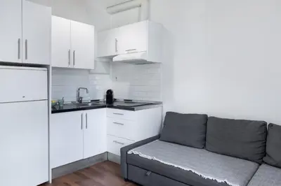 a living room with a couch and a kitchen at Up Town in Valencia