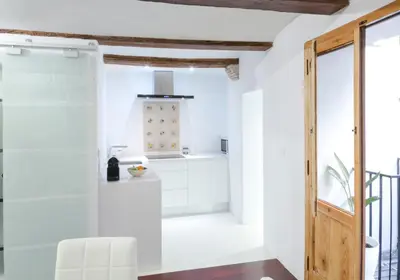 a kitchen with white walls and a wooden door at Apartments Downtown Valencia in Valencia